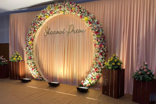 Elegant engagement stage decoration with roses and fairy lights.