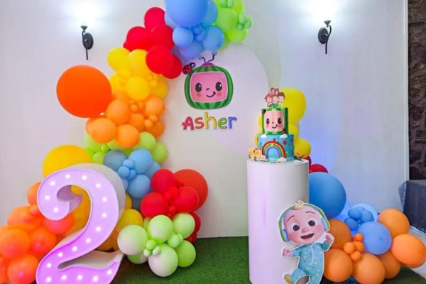 Bright Coco Melon Sunshine Smiles balloon arch and stage setup