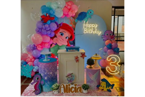 Mermaid theme birthday decoration setup with ocean props and balloons.
